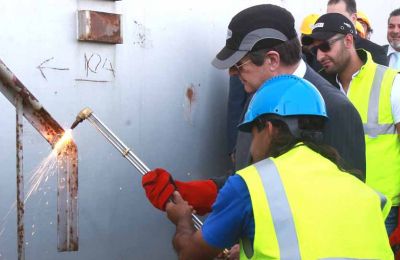 Cyprus President Nicos Anastasiades helps cut a piece during a ceremony ahead of an oil tank demolition in Larnaca