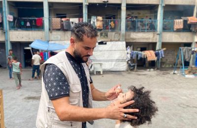 UNRWA aid worker giving polio vaccine to a child in Gaza - Social Media photo X