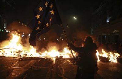 Thousands of demonstrators wave Georgian and EU flags outside the parliament building in Tbilisi. Credit: AP