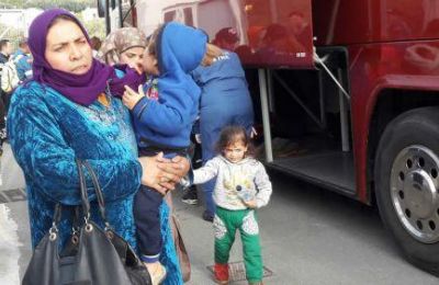 A Syrian family prepares to board a bus, marking the start of their journey. Credit: CNA