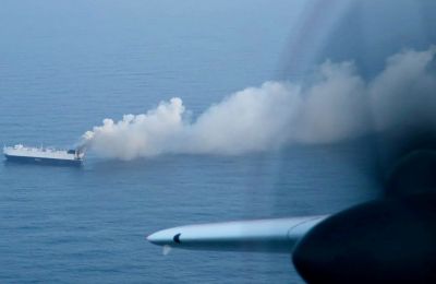 Smoke rises from a fire aboard the cargo vessel Morning Midas, carrying around 3,000 vehicles, including 800 electric vehicles. US Coast Guard picture.