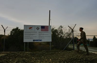A Cypriot officer walks next of a sign bearing US and Cypriot flags at the site of a new helipad planing construction at the Evangelos Florakis naval base in Mari on April 17.[Petros Karadjias/AP]