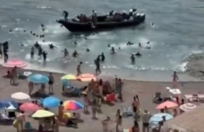Dozens of migrants rush ashore at crowded Spanish beach (video)